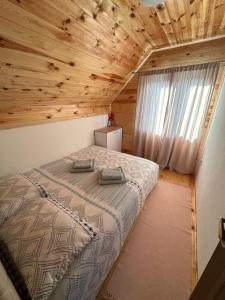 a bed in a room with a wooden ceiling at Blue Village Lux in Kolašin