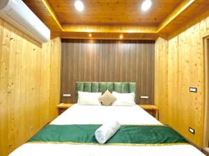 a bedroom with a large bed with wooden walls at The Walnut Homestay I Kasauli I Perfect Stay in Kasauli
