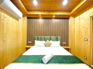 una camera da letto con un grande letto e pareti in legno di The Walnut Homestay I Kasauli I Perfect Stay a Kasauli