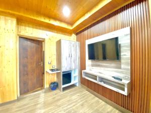 una camera con TV su una parete in legno di The Walnut Homestay I Kasauli I Perfect Stay a Kasauli Altre 13 foto