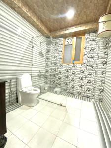 bagno con servizi igienici e parete in pietra di The Walnut Homestay I Kasauli I Perfect Stay a Kasauli