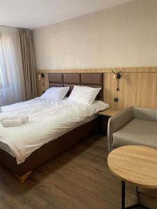 a bedroom with a bed and a table and a chair at Deers in Bansko