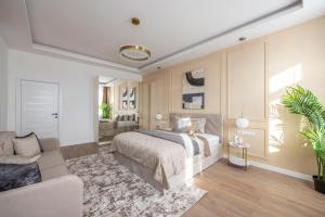 Luxury & Classy Central Apartment with 3BEDRM, 2BATHRM في بودابست: غرفة نوم بسرير واريكة