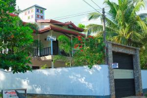 a house with a gate in front of it at Bandara House in Midigama East