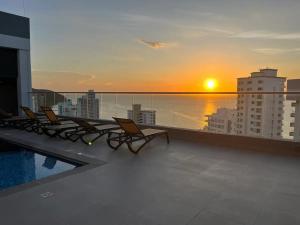 - Balcón con sillas y puesta de sol en un edificio en Apartamentos Ambar Roca - Cerca al Mar by SOHO, en Santa Marta