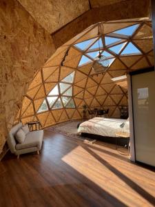 a large room with a bed and a couch in it at Miradomos Glamping Rural in Lodares de Osma