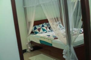 a bedroom with a bed with curtains and a mirror at Bandara House in Midigama East
