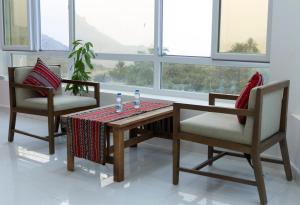 a dining room with a table and two chairs at Hadash guest house in Ghubrah