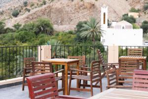 un grupo de mesas y sillas en un balcón en Hadash guest house, en Ghubrah