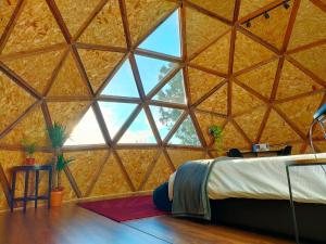 Lodares de OsmaにあるMiradomos Glamping Ruralのベッド1台と大きな窓が備わる客室です。