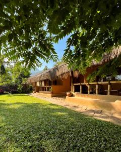 een gebouw met een grasdak en een tuin bij The Mudhouse Marayoor in Munnar