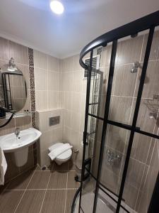 y baño con ducha, aseo y lavamanos. en Bella Otel Mudanya, en Mudanya