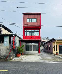 um edifício vermelho no lado de uma rua em Hello em Fang-liao