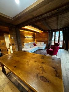 uma sala de estar com uma grande mesa de madeira e cadeiras em Alpine Escape 3 em Bormio