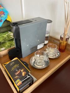 a coffee maker on a wooden tray with plates and cups at Appartement terrasse vue mer dans village Pierre Vacances in Sainte-Luce