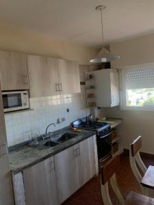 a kitchen with a sink and a stove at Departamento en Ramallo in Ramallo