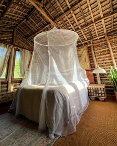 un letto in una camera con zanzariera di The Mudhouse Marayoor a Munnar
