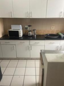 eine Küche mit einer Arbeitsplatte mit einem Toaster und einer Mikrowelle in der Unterkunft Grandborough in Durban