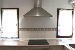 una cocina con capucha sobre una barra de cocina en Sobre Los Tilos Apartamento, en Cuenca
