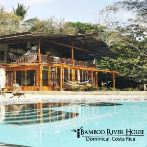 a house with a swimming pool in front of it at Bamboo River House and Hotel in Dominical