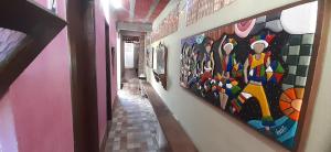 a hallway with several paintings on the wall at ROSÁRIO TEMPORADA Hostel in Olinda