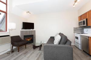 uma sala de estar com um sofá e uma lareira em Alpenglow Lodge Junior Penthouse by MVA em Whistler