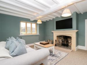 a living room with a couch and a fireplace at Wood Stanway House in Cheltenham