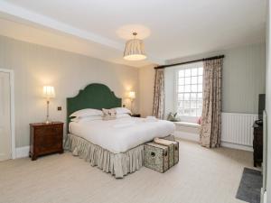 a bedroom with a large bed and a large window at Wood Stanway House in Cheltenham