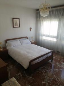 a bedroom with a large bed and a chandelier at casa el chiquitín in La Zubia