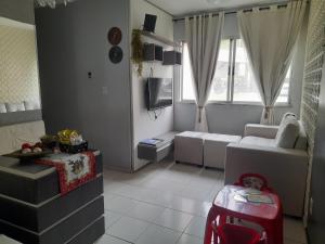 a living room with a couch and a tv at Apartamento confortável e sofisticado em Aracaju in Aracaju