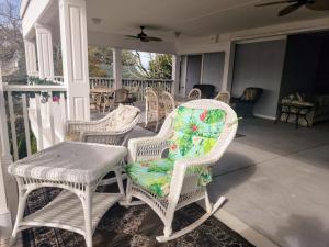 un grupo de sillas de mimbre y una mesa en un porche en Beaufort Harbour Suites and Lodges, en Beaufort