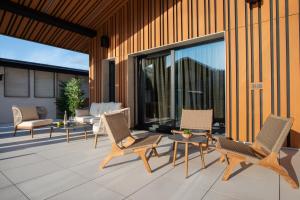 Un patio con sillas y mesas en un edificio. en Alpine Bell Villa, en Banya