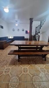 a large wooden table in a room with a couch at Casa com Jacuzzi aquecida praia do Lazaro in Ubatuba