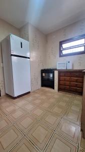 uma cozinha com um frigorífico branco num quarto em Casa com Jacuzzi aquecida praia do Lazaro em Ubatuba