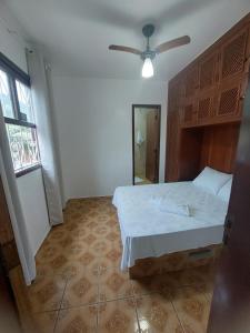 um quarto com uma cama e uma ventoinha de tecto em Casa com Jacuzzi aquecida praia do Lazaro em Ubatuba