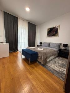 a bedroom with a large bed and a blue ottoman at KM Apartments in Zagreb