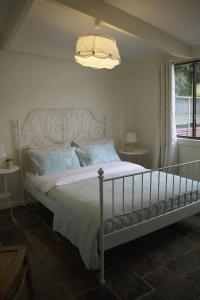 a bedroom with a white bed and a chandelier at Bickley Valley Cottage in Bickley