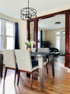 a dining room with a table with white chairs and a dining roomiasm at Abode à la Mode / Centrally Located 2BR/1BA Home in Evansville