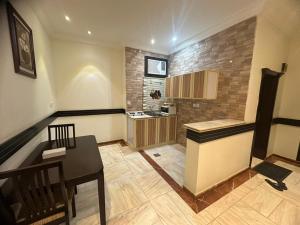 a kitchen with a table and a counter in a room at لجين الجوهرة للوحدات المخدومة in Al ‘Azīzīyah