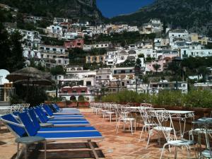 a row of blue chairs and tables on a mountain at Hotel Posa Posa in Positano