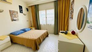 ein Hotelzimmer mit einem Bett und einem Fenster in der Unterkunft Bungalow S+1 au port de Kantaoui, Sousse. Avec balcon offrant une panorama envoûtant in Sousse