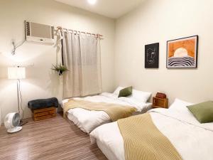 um quarto com três camas e uma janela em 青青小院 Qing Yard em Tainan