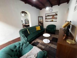 a living room with a green couch and a tv at Casa San Lorenzo in Huánuco