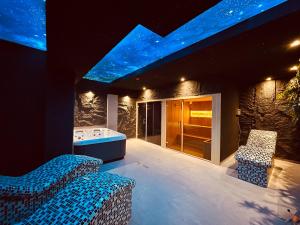 une chambre avec une baignoire et une chambre avec des lumières bleues dans l'établissement MOZAIK Apartments & Spa - Modern Apartments with Exclusive Spa Wellness in the City Center, Free Parking, Wi-FI, Sauna, Jacuzzi, Salt Wall, à Ćuprija