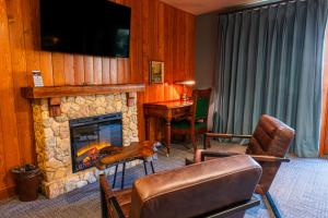 a living room with a stone fireplace and a desk at Mt. Lemmon Lodge in Loma Linda