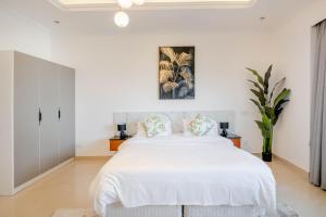 a white bedroom with a large white bed with pillows at Beautiful Al Marjan sea view Apartment in Ras al Khaimah