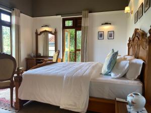 a bedroom with a large bed and a desk at Gannoru Hatana Villa in Kandy