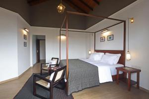 Gannoru Hatana Villa في كاندي: غرفة نوم بسرير كبير وكرسي