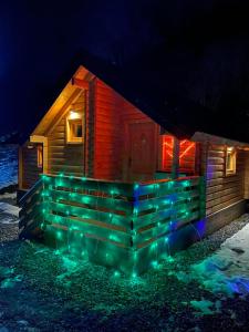 a cabin covered in lights in the snow at night at Wooden Corner in Kolašin