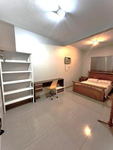 1 dormitorio con cama, escritorio y escalera en Hospedagem aconchegante com área gourmet, en Araguaína